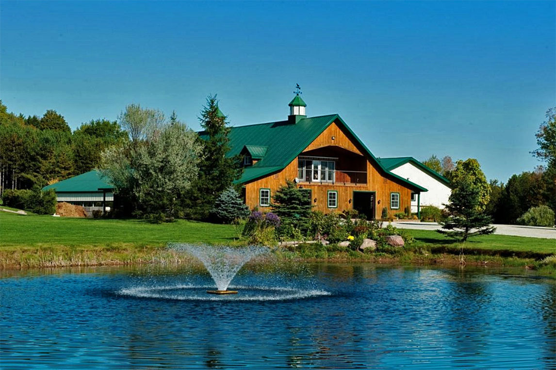 Horse barn renovation with pond fountain in the foreground